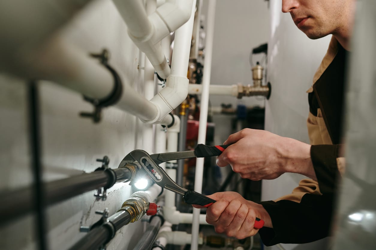 Plumbers maintaining commercial plumbing pipes in Firestone