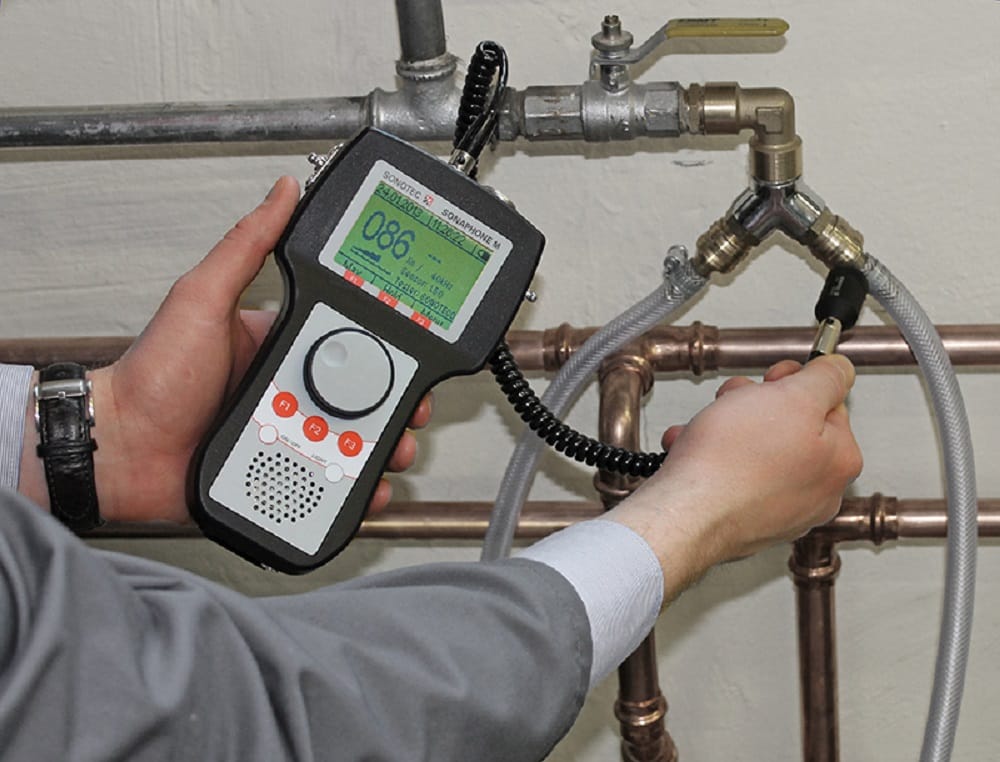 Plumber testing pipes with electronic leak detection equipment in Firestone