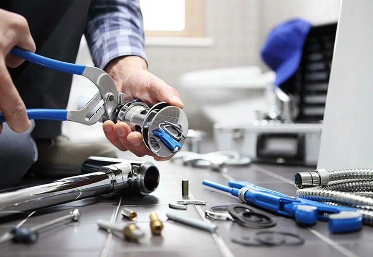 Technician repairing a plumbing fixture with professional tools in Firestone