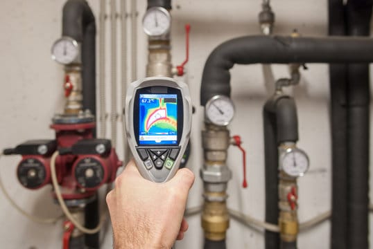 Plumber using a thermal imaging camera to inspect pipes in Firestone