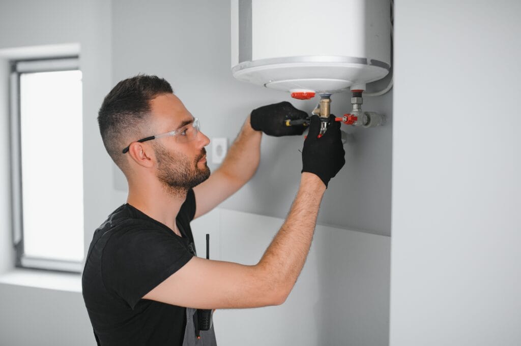 Technician performing water heater maintenance in Firestone