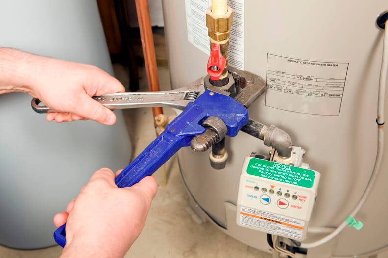 Plumber repairing a water heater valve in Firestone